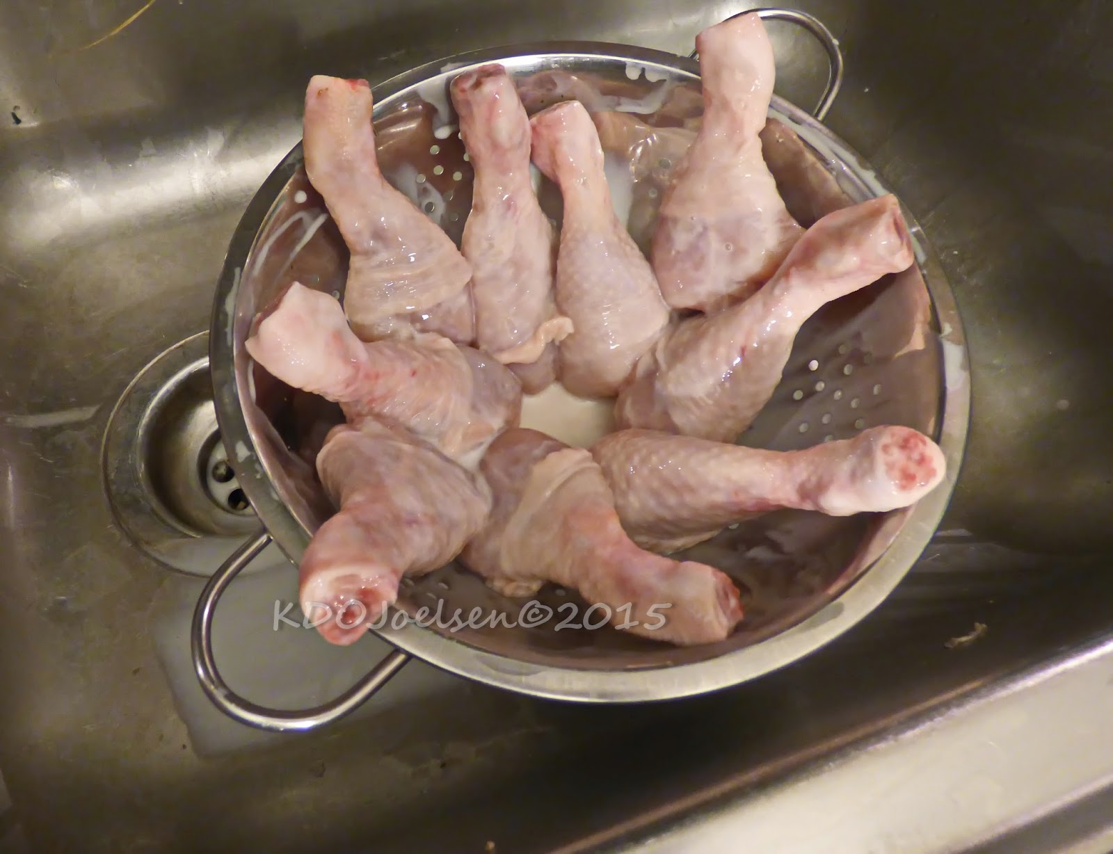 Chicken legs being drained from buttermilk